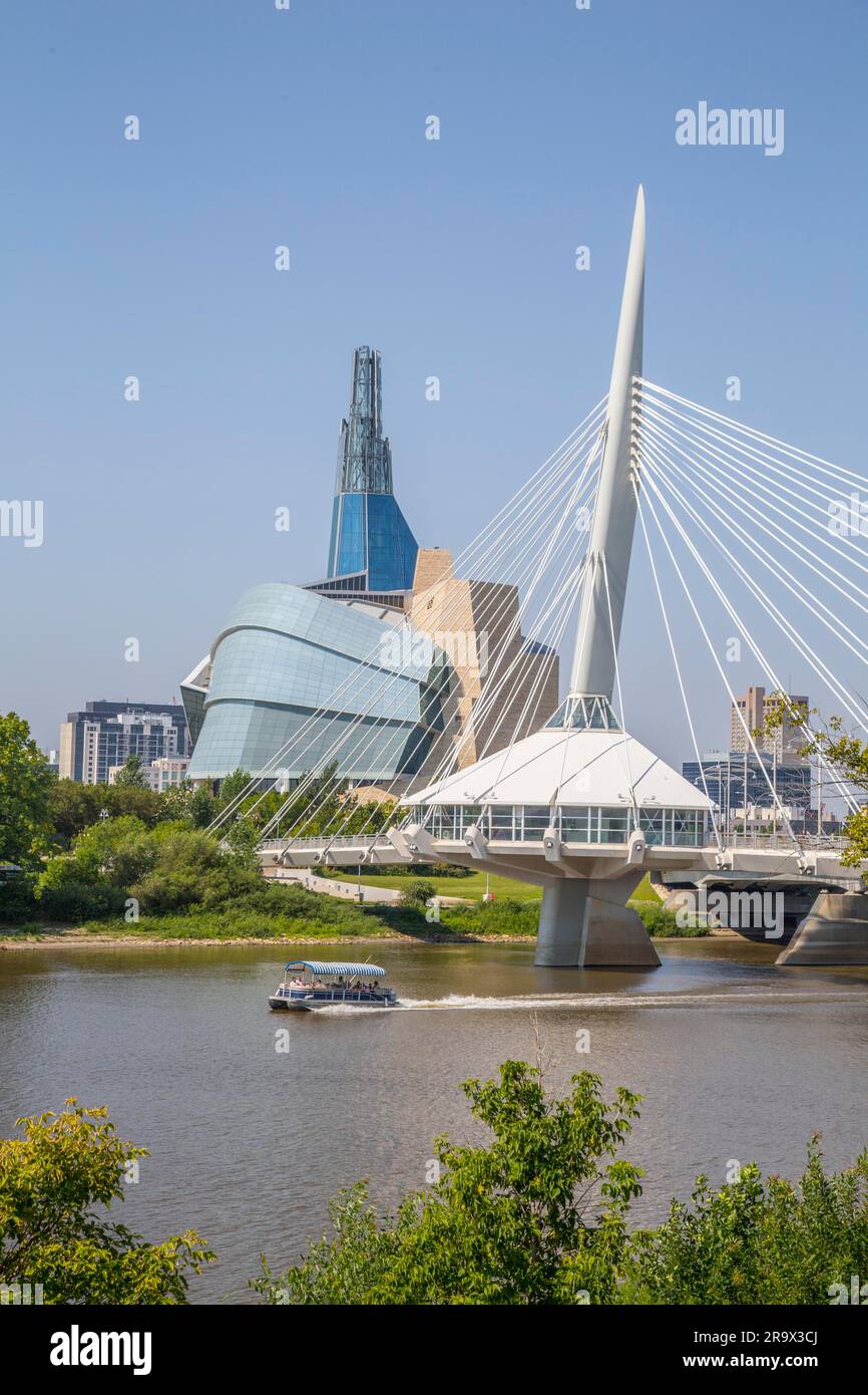 Vista desde el paseo tache del río Rojo con el puente Provencher y el horizonte de Winnipeg detrás de él, el Museo Canadiense de los Derechos Humanos en el Foto de stock