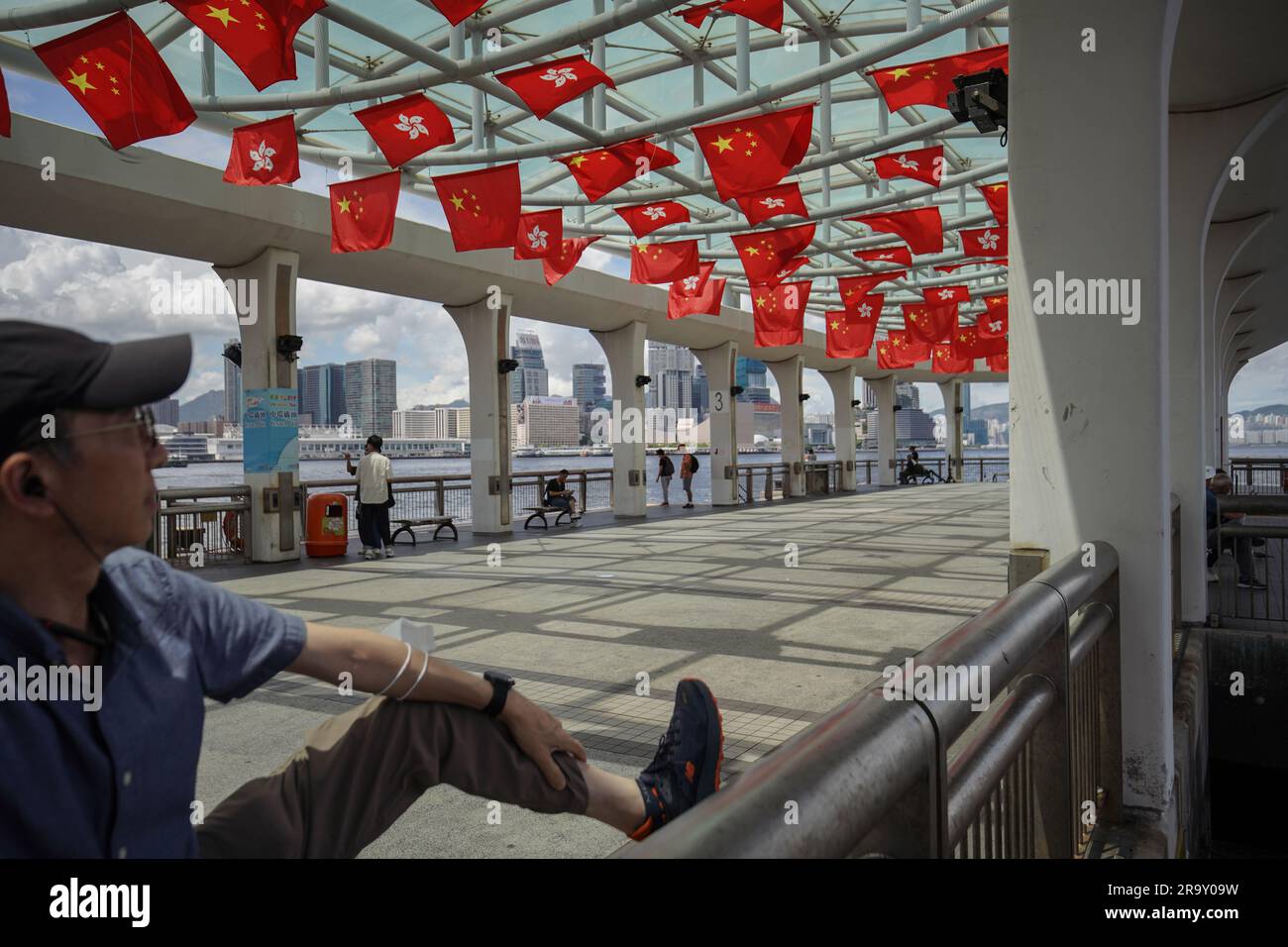 Un hombre observa las banderas de China y Hong Kong en un muelle. A