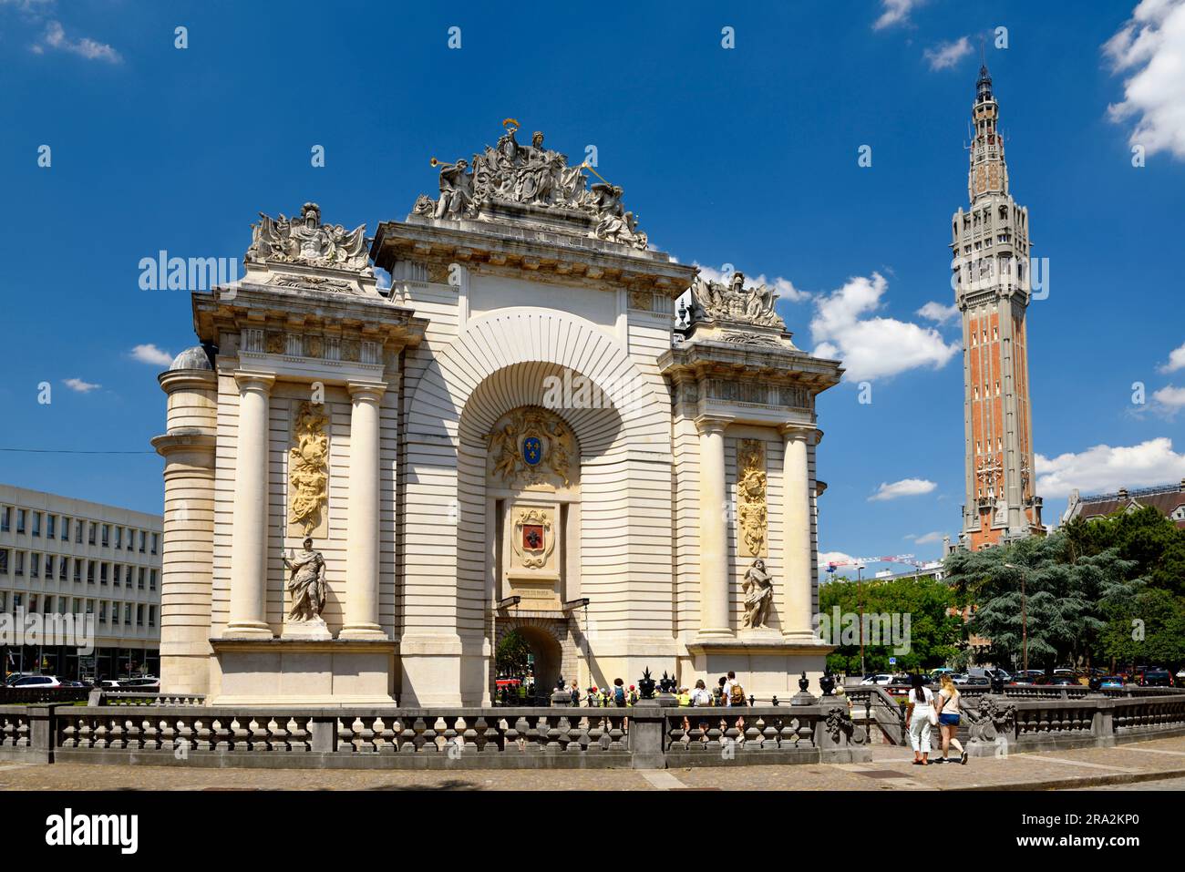 Francia, Norte, Lille, Porte de Paris y campanario del ayuntamiento, catalogados como Patrimonio de la Humanidad por la UNESCO en el fondo Foto de stock