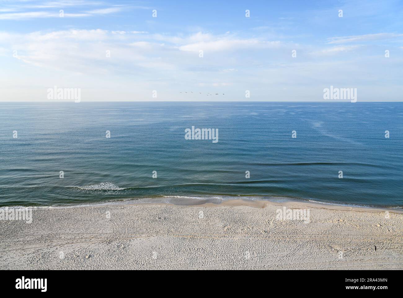 Vista aérea de la playa vacía de Gulf Shores en la mañana temprano cubierta con huellas de pies y pistas del día anterior Foto de stock