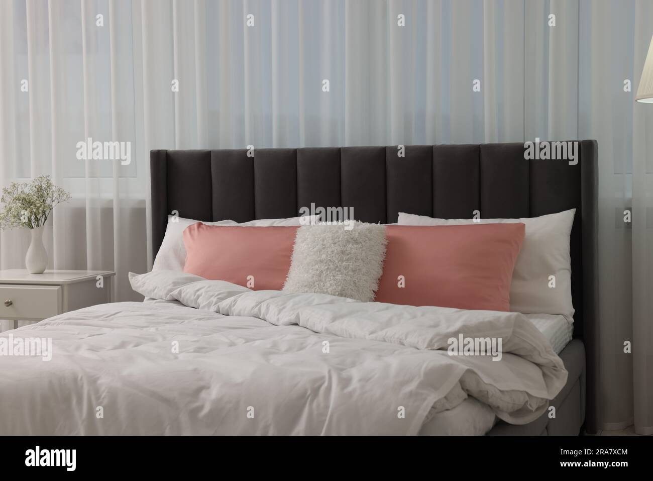 Almohadones decorativos de acuerdo con cama dormitorio lámparas y mesitas de  noche Fotografía de stock - Alamy