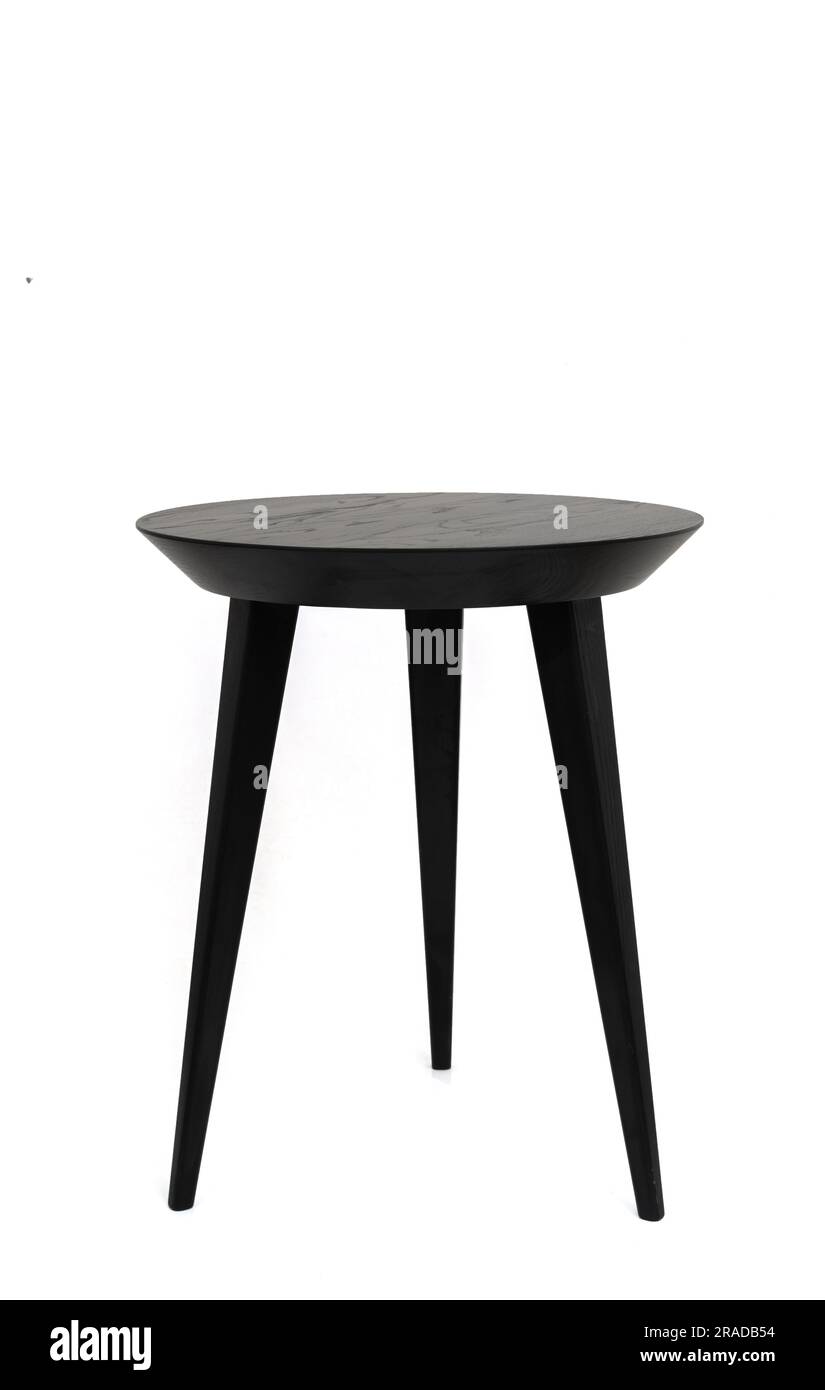 Mesa de centro redonda de madera negra en tres patas con una hermosa textura de madera. Aislado sobre un fondo blanco Foto de stock