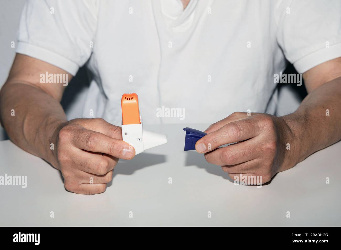 Hombre sosteniendo el inhalador de asma en sus manos. Medicamentos para el asma inhaladores sobre un fondo blanco. Enfermedad pulmonar. Foto de stock