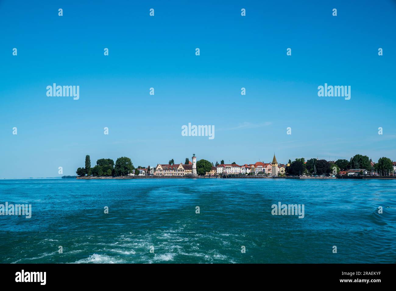 Alemania, Bodensee lago constanza, hermosa vista en la ciudad histórica de la isla de lindau desde el ferry en el agua en verano con el cielo azul y el sol Foto de stock