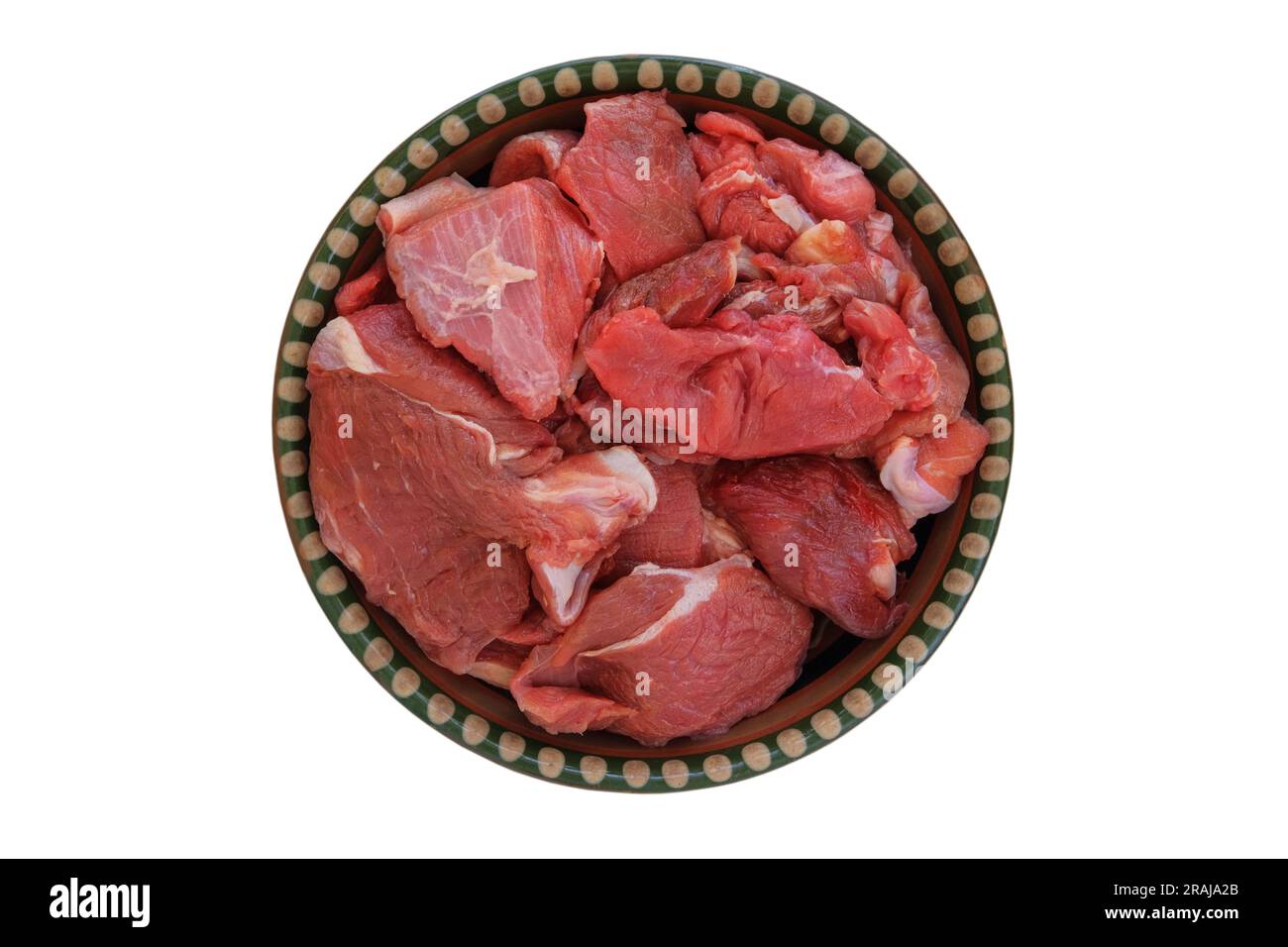 Trozos de carne en un plato rústico aislado sobre fondo blanco. Carne cruda para cocinar. Vista superior. Foto de stock