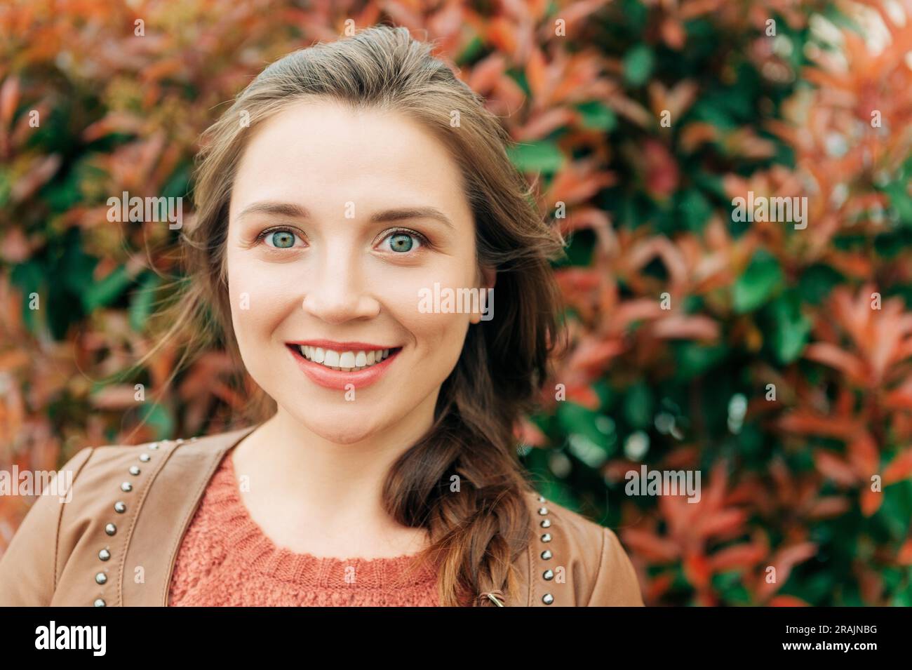 Retrato de moda de mujer joven hermosa de 25-30 años con maquillaje  profesional, con chaqueta de cuero marrón, Jersey de punto y jeans  rasgados, p Fotografía de stock - Alamy