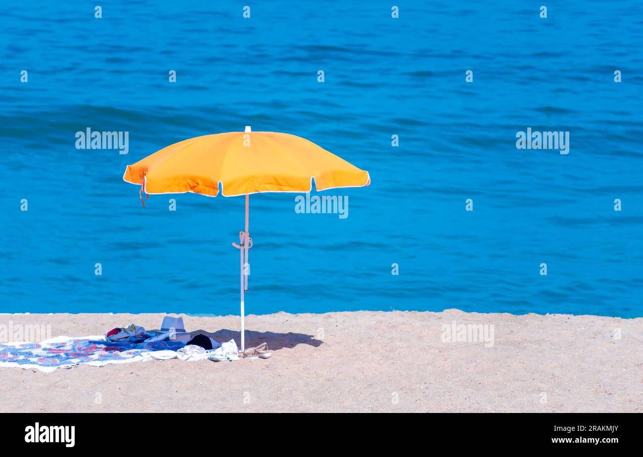 Símbolo de vacaciones en la playa, una sombrilla naranja en la playa frente al mar en Espinho, Portugal Foto de stock