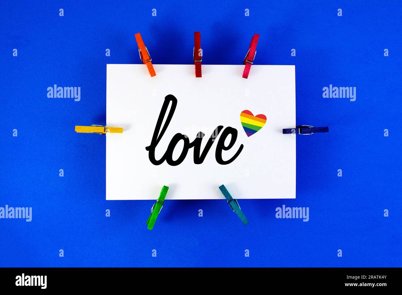 Tarjeta adjunta con pinzas con la palabra amor y corazón Foto de stock