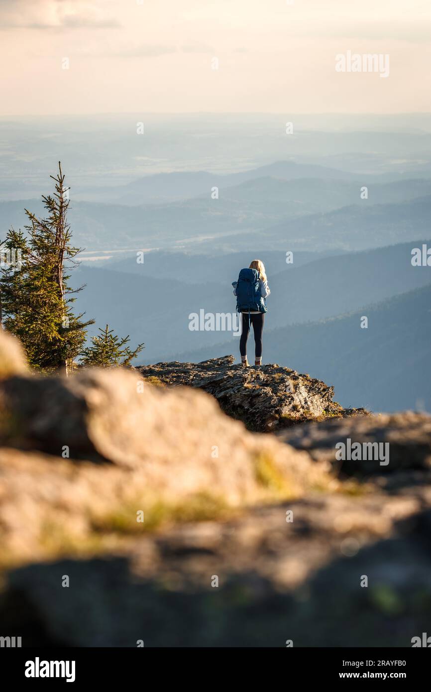 El excursionista escaló con éxito la cumbre de la montaña. Mujer caminando en las montañas Foto de stock