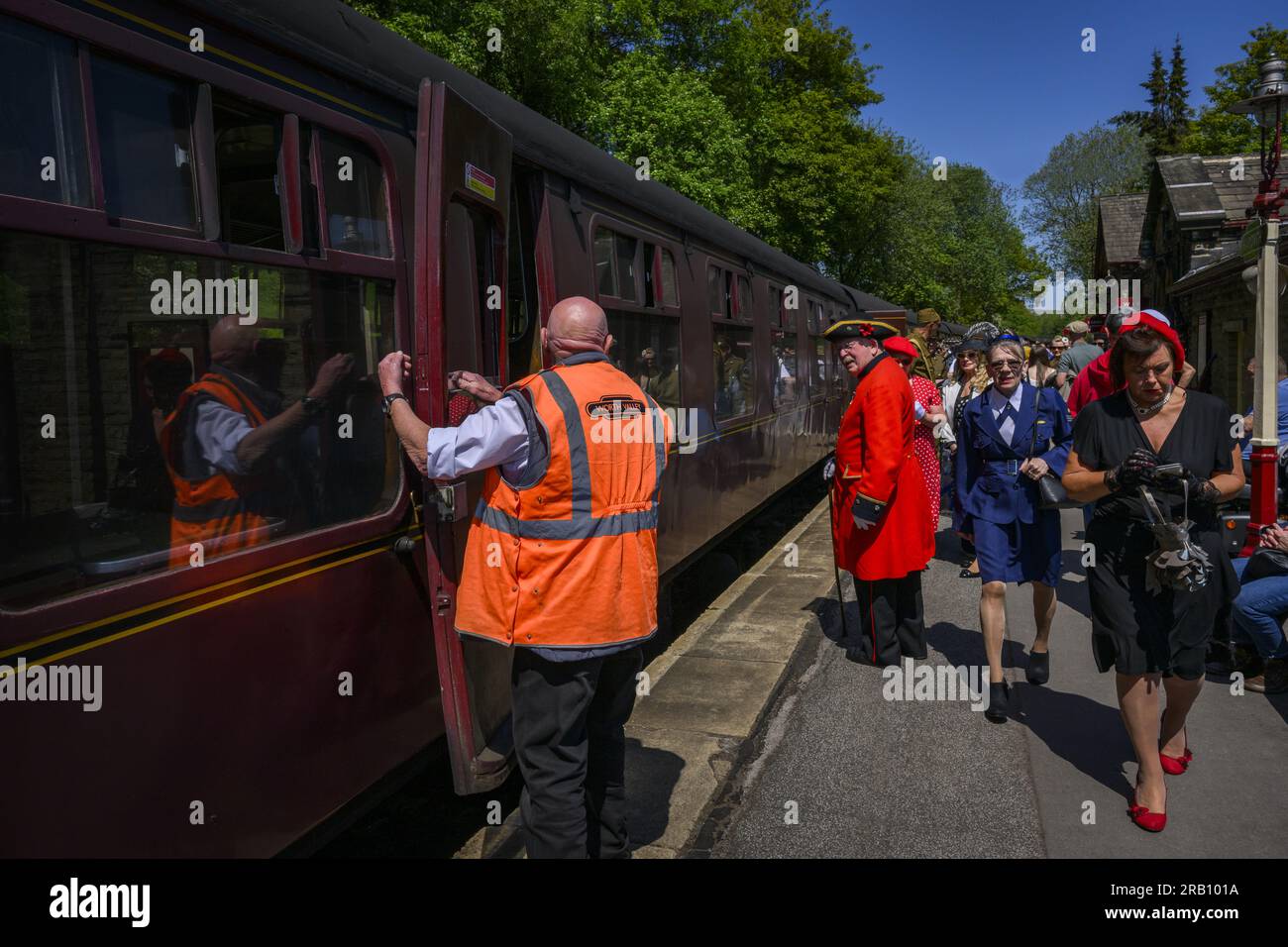 Recreación nostálgica de 1940 (moda retro, material rodante antiguo, carro estacionario, puerta abierta) - KWVR, Haworth Station, West Yorkshire, Inglaterra, Reino Unido. Foto de stock