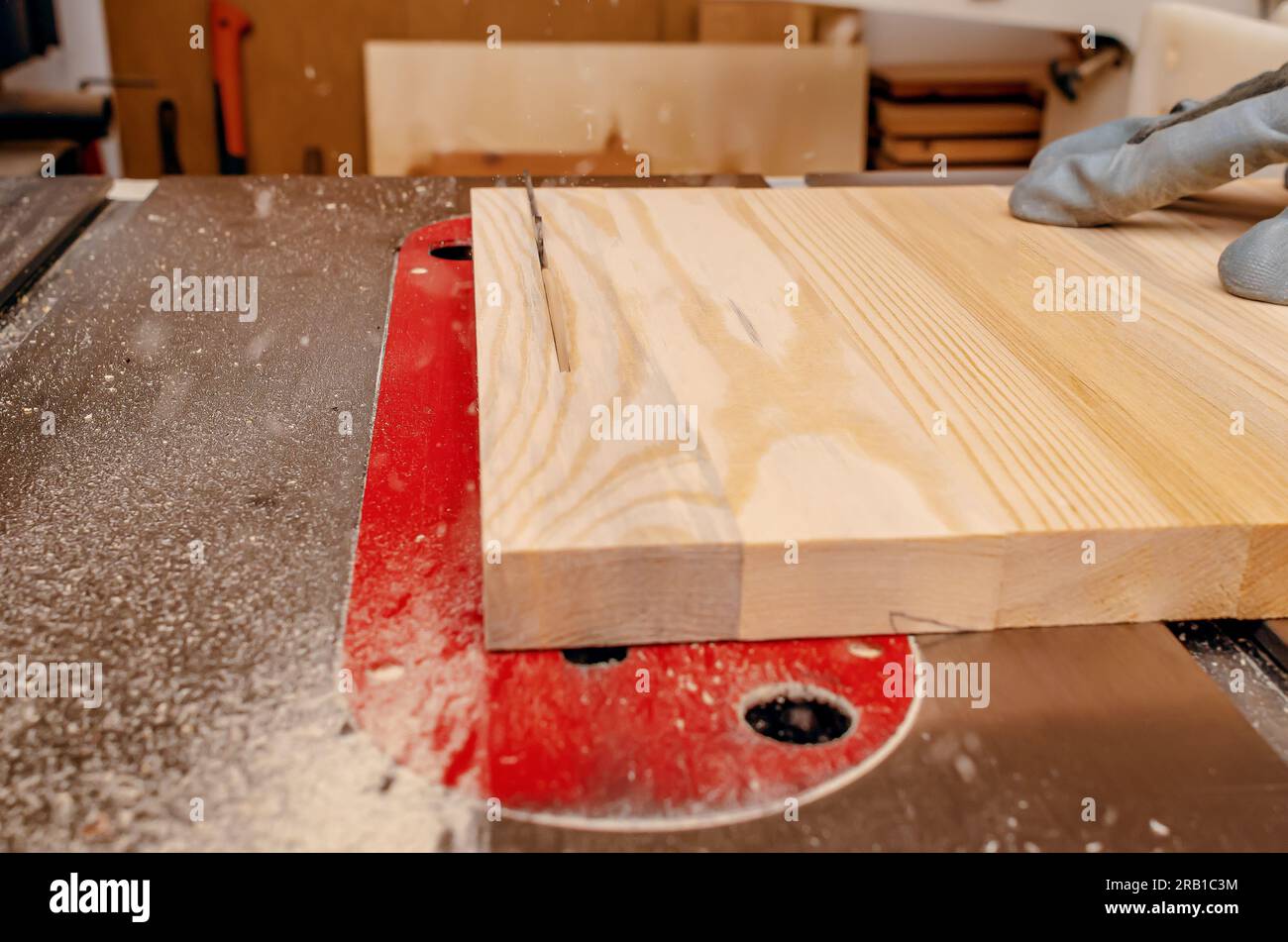 Máquina de carpintería. La cuchilla afilada de la sierra circular corta el tablero de madera. Alta velocidad de rotación. Foto de stock
