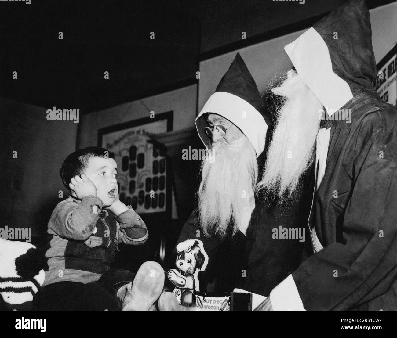 Chicago, Illinois: 14 de noviembre de 1941 Un niño reacciona en estado de shock cuando ve dos cláusulas de Santa. Resulta que son solo ayudantes de Santa trabajando para los Voluntarios de América. Foto de stock