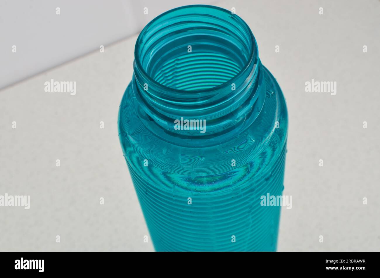 Detalle de una botella de agua azul, el compañero perfecto para los deportistas que valoran una hidratación adecuada. Foto de stock