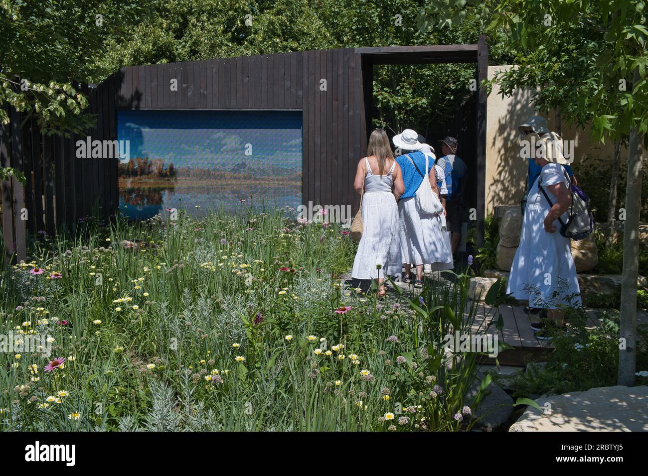 Los visitantes admiran uno de los jardines del espectáculo en el RHS Hampton Court Flower Show en Londres Foto de stock