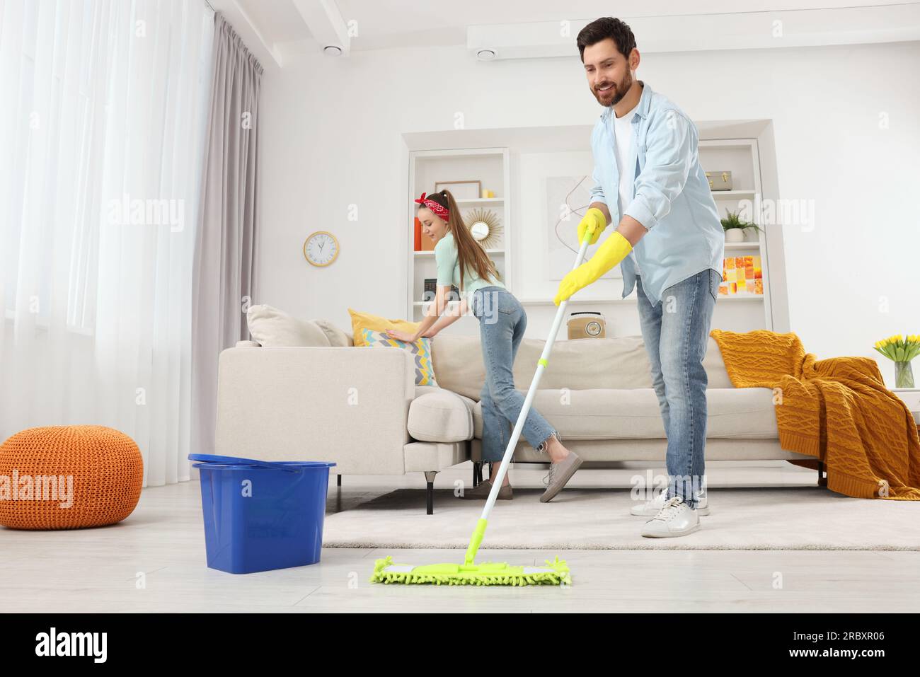 Pareja disfrutando de la limpieza de su casa con aspiradora y fregona  Fotografía de stock - Alamy