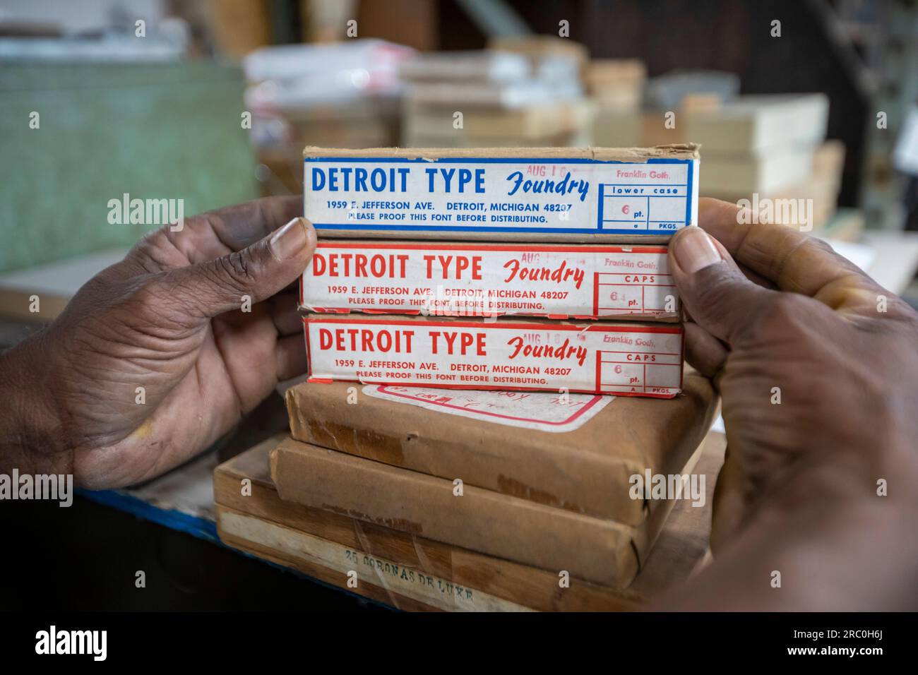 Detroit, Michigan - En su imprenta de tipografía, Amos Kennedy sostiene contenedores sin abrir de tipo Franklin Gothic de la antigua Detroit Type Foundry. Foto de stock