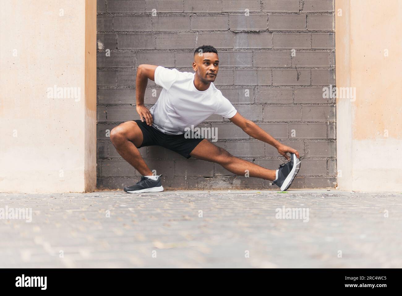 Atleta masculino negro concentrado en ropa deportiva y zapatillas