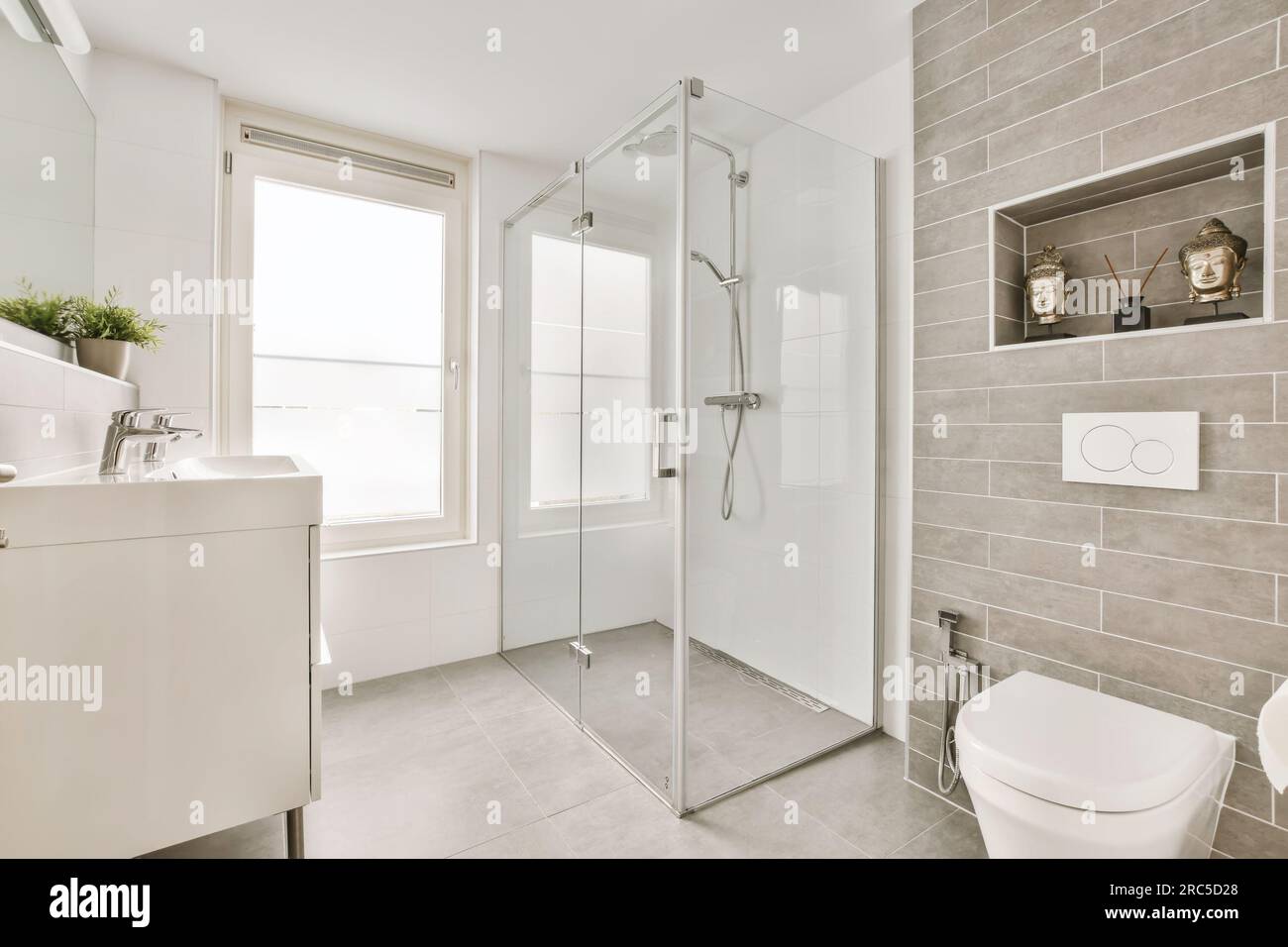 un cuarto de baño con inodoro, lavabo y ducha en las esquinas en el lado izquierdo de la habitación Foto de stock