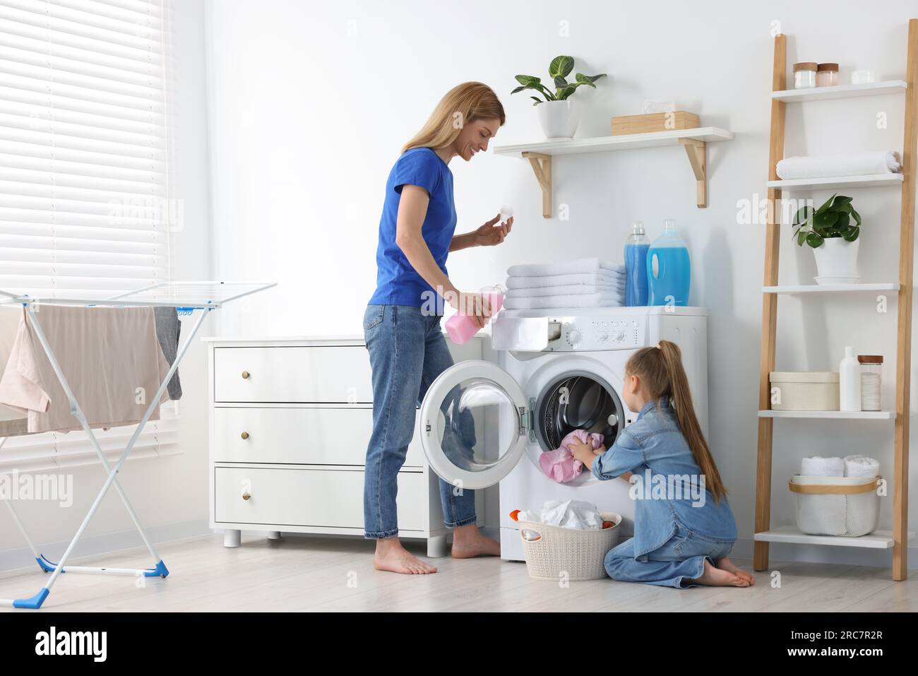 Madre e hija lavando ropa juntos Fotografía de stock - Alamy