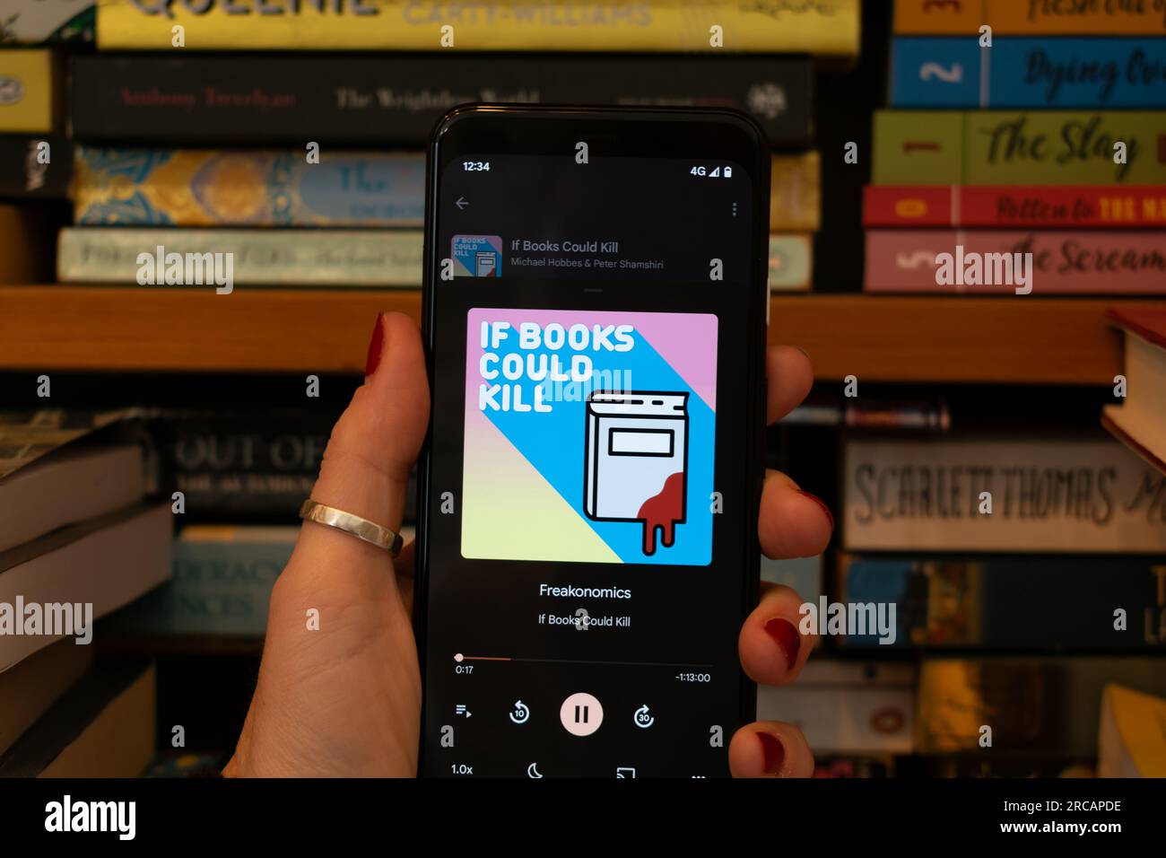 Podcast Si los libros podrían matar a jugar Freakonomics en el teléfono Google Pixel. Libros de enfoque suave en el fondo. Foto de stock