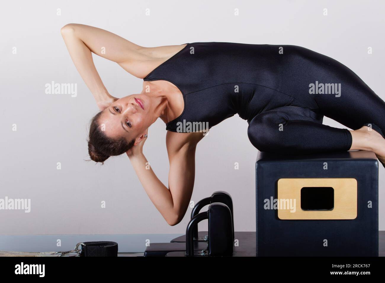 máquina de pilates, mujer de raza mixta joven en ropa deportiva que hace  ejercicio en el gimnasio Fotografía de stock - Alamy