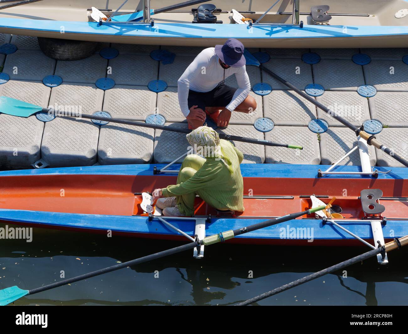 El instructor de remo masculino explica cómo a una estudiante musulmana mujer se puede sujetar a un bote de remo. Anadolu en el lado asiático de Estambul, Turquía Foto de stock