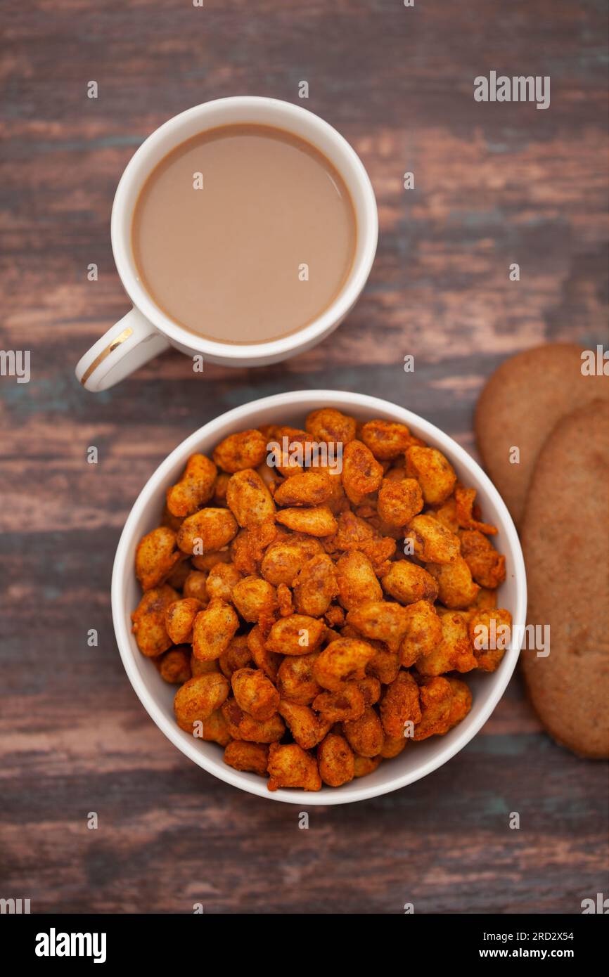 Primer plano de aperitivos crujientes de mezcla india con té caliente o café y galletas hechas a mano Foto de stock
