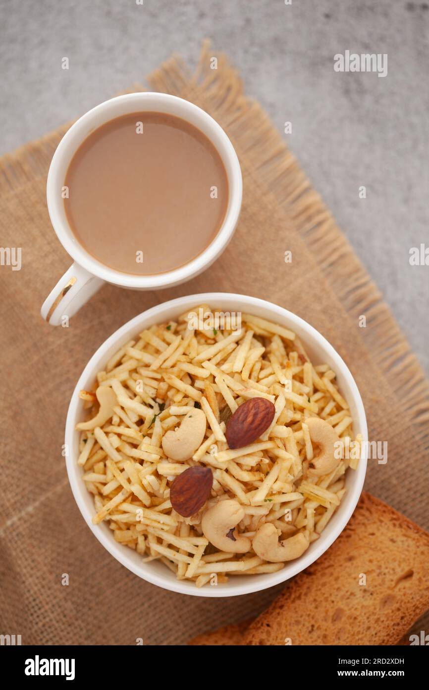 Primer plano de aperitivos crujientes de mezcla india con té caliente o café y galletas hechas a mano Foto de stock