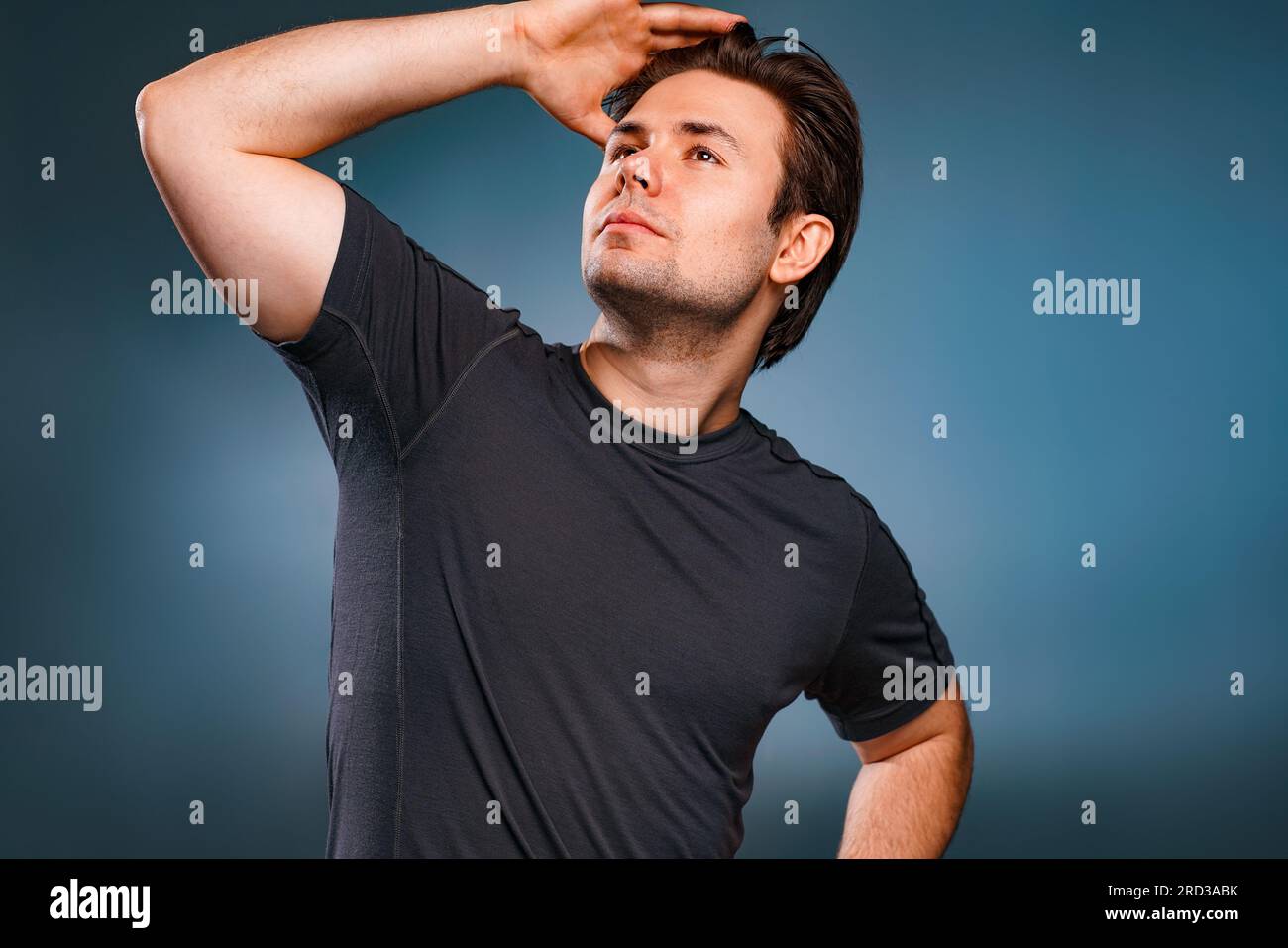 Joven hombre guapo posando sobre fondo gris Foto de stock