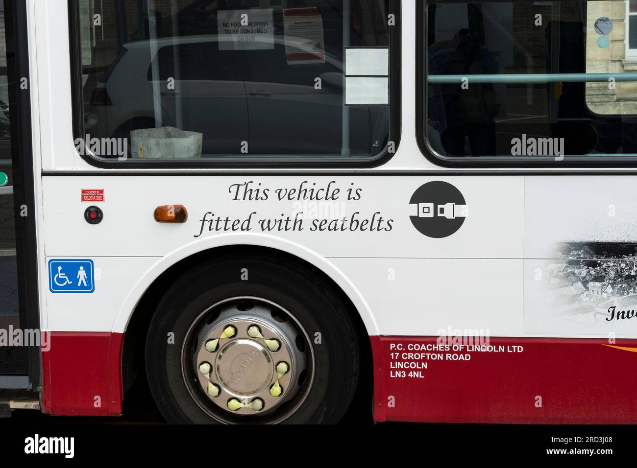 Este vehículo está equipado con un aviso de cinturones de seguridad estampado en el lado del autobús P.C.Coaches, St Mary's Street, Lincoln City, Lincolnshire, Inglaterra, REINO UNIDO Foto de stock