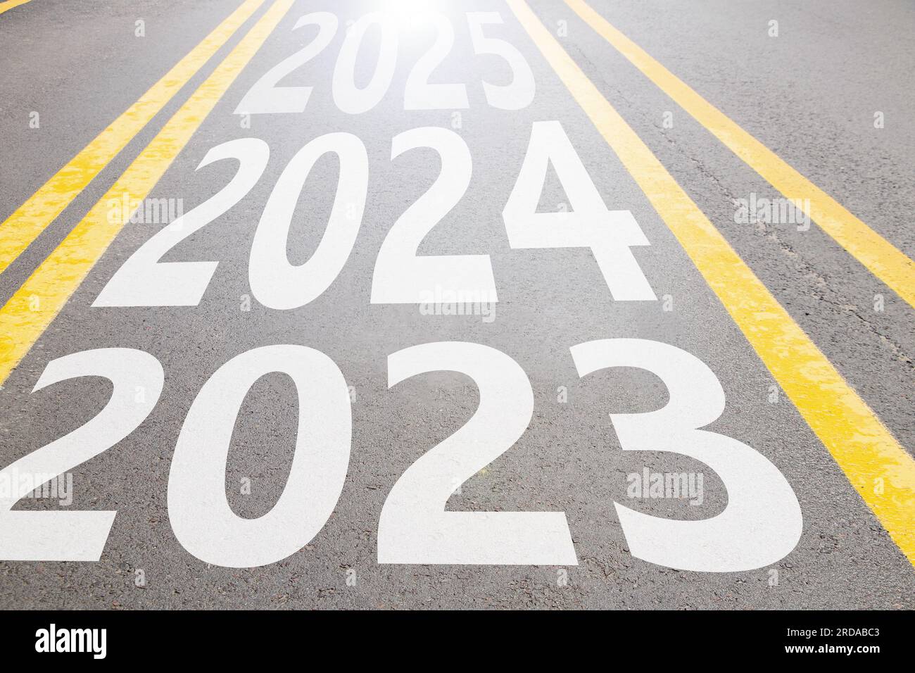 2023 y 2024 y 2025 escritos en el camino de asfalto que avanza en