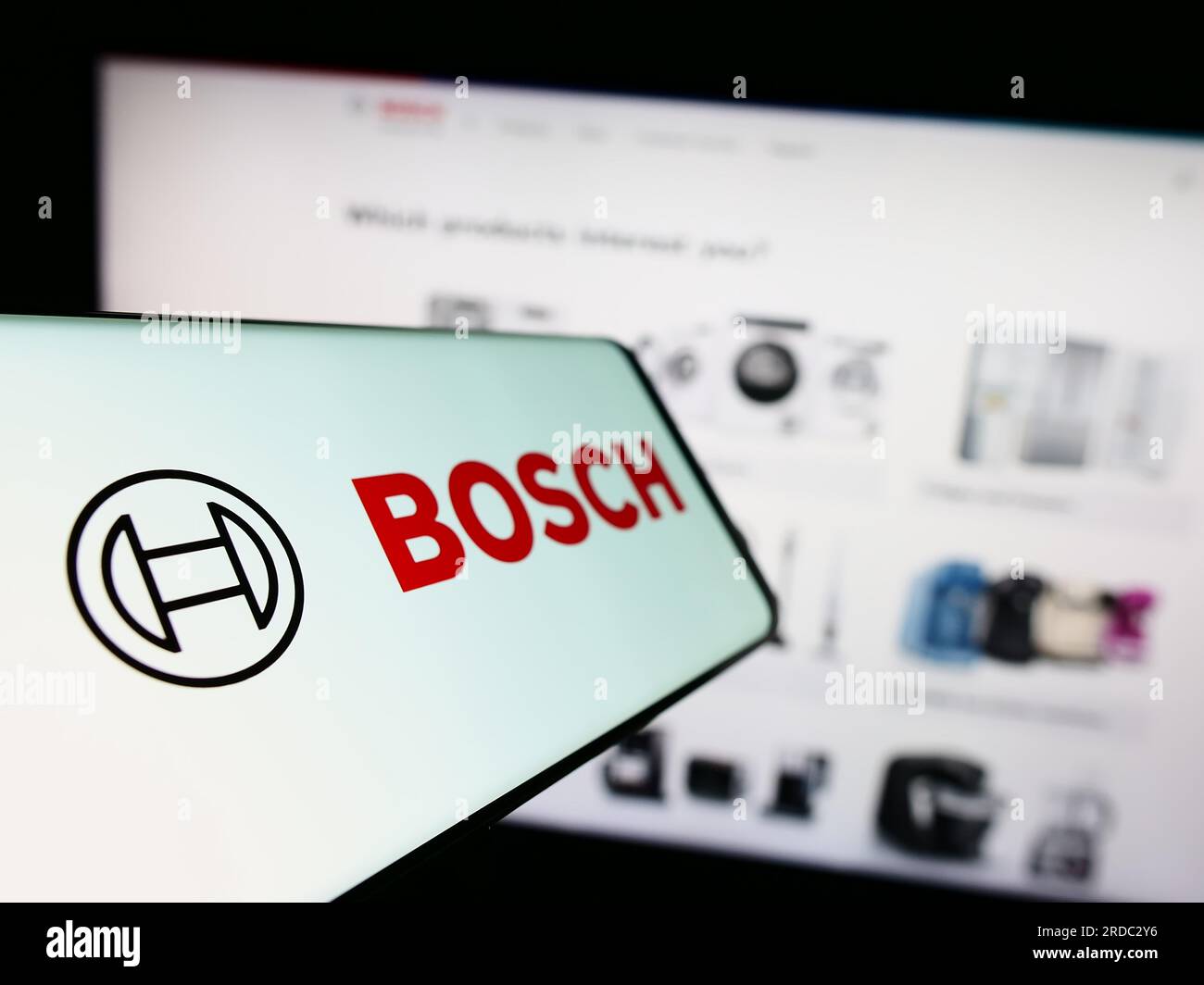 Teléfono móvil con el logotipo de la empresa de ingeniería alemana Robert Bosch GmbH en la pantalla delante del sitio web. Enfoque en el centro izquierdo de la pantalla del teléfono. Foto de stock