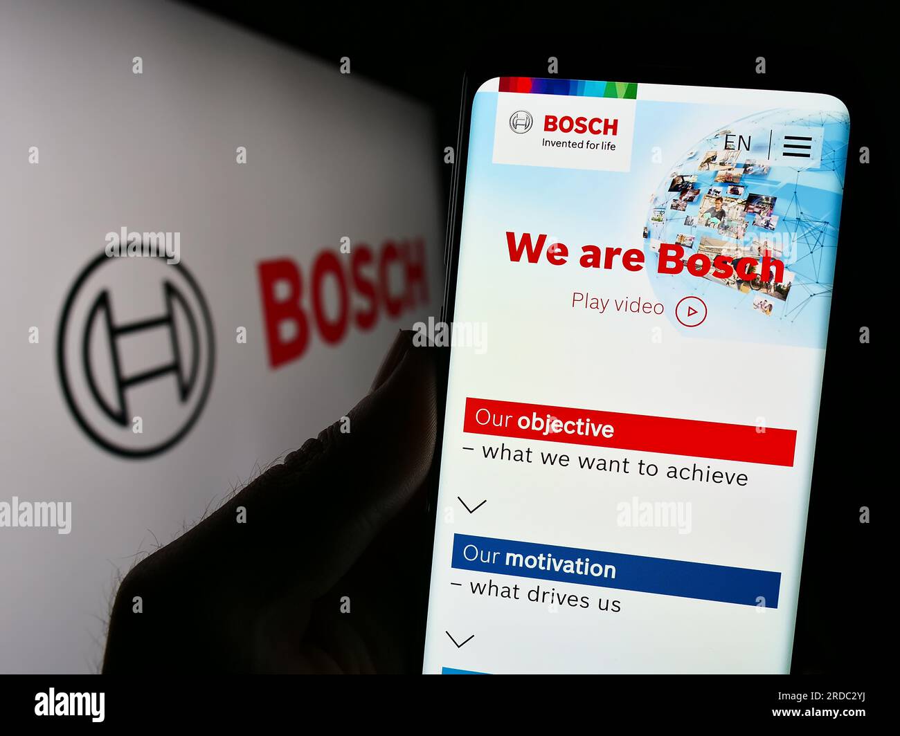 Persona que sostiene el teléfono inteligente con el sitio web de la empresa de ingeniería alemana Robert Bosch GmbH en la pantalla con el logotipo. Enfoque en el centro de la pantalla del teléfono. Foto de stock