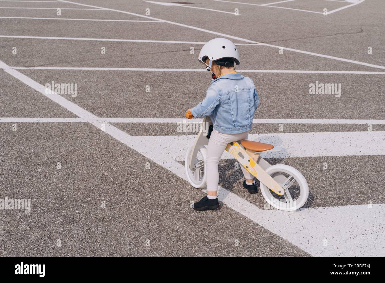 Un niño de 2 años aprende a andar en bicicleta de equilibrio en la  carretera de la aldea.