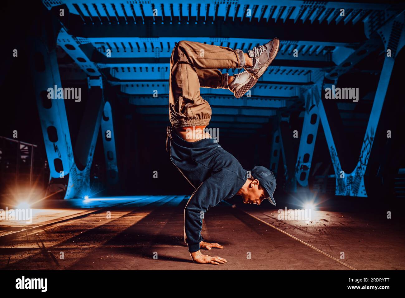Joven hombre fresco romper bailarín posando en puente urbano en la noche Foto de stock