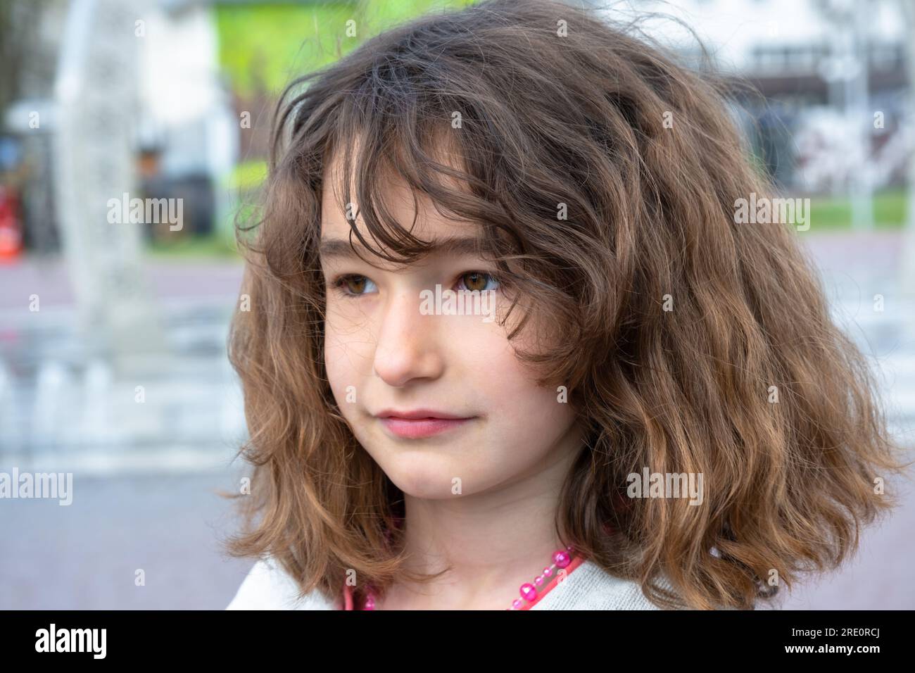 Un bebé de pelo rizado se asienta sobre un fondo blanco y sonrisas  Fotografía de stock - Alamy