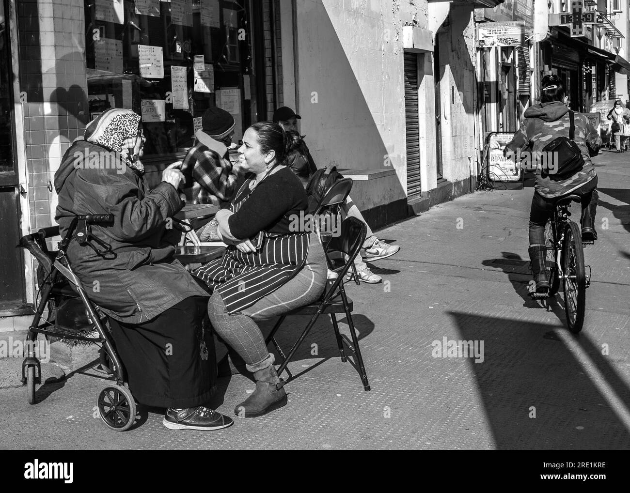 mujer joven y vieja hablando escena de la calle Foto de stock
