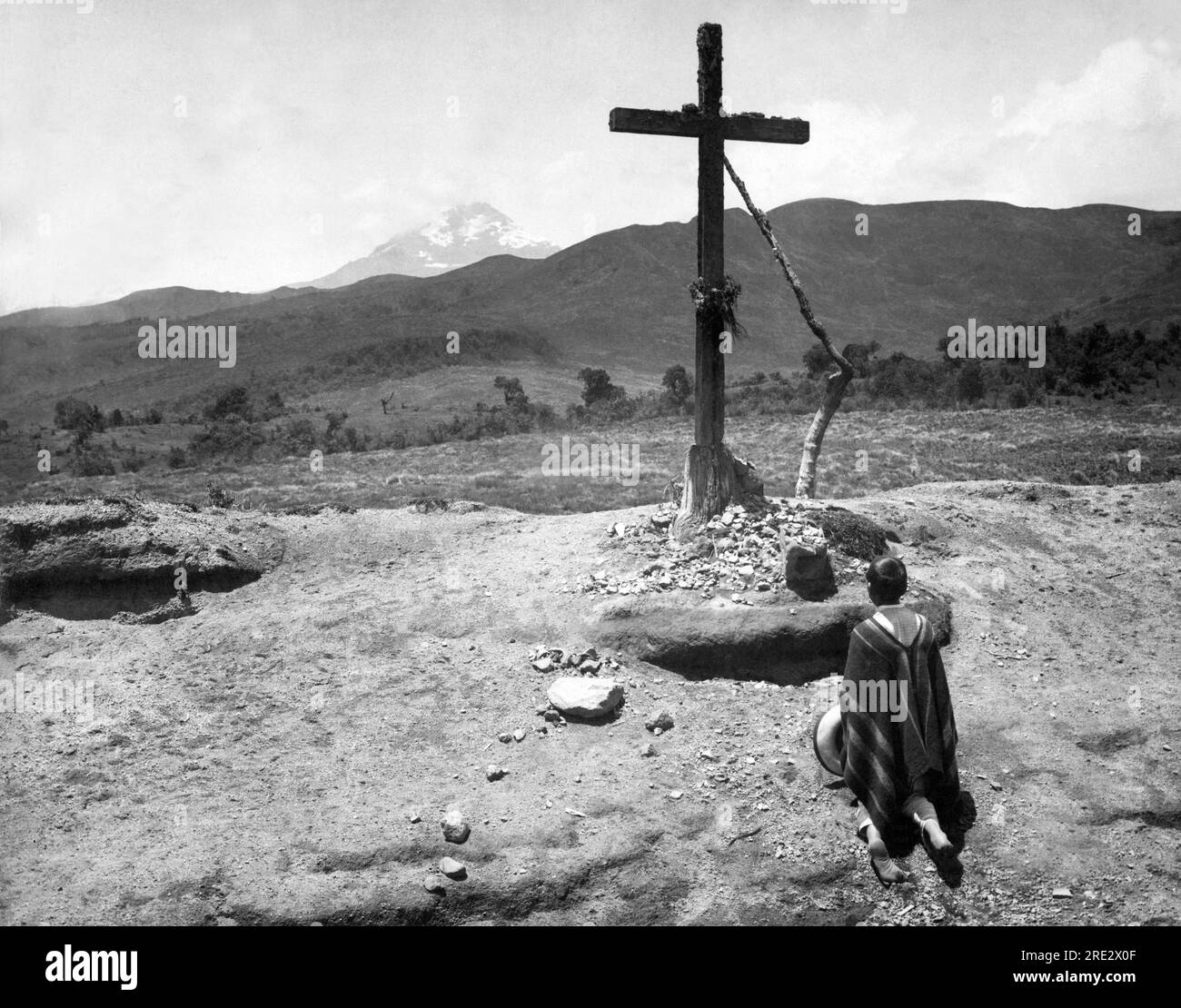 Ecuador: c. 1900 Un devoto caminante se detiene ante un solitario santuario en el camino a Quito. Foto de stock