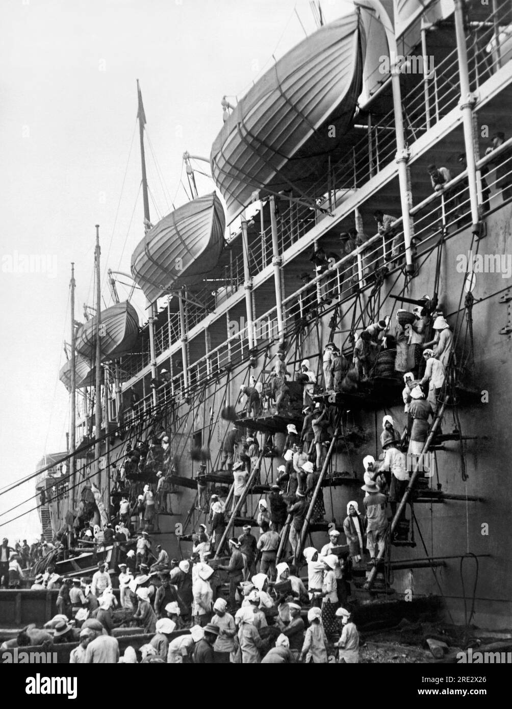 Japón: c. 1904 líneas de hombres y mujeres que pasan cestas de carbón por las escaleras para alimentar la Pacific Mail Steamship Company, la S.S. Siberia. Foto de stock