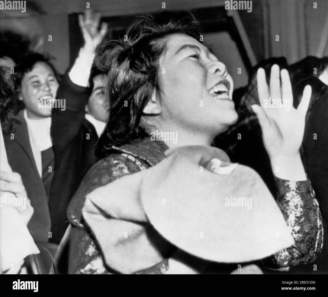 Tokio, Japón: 1958 Estos entusiastas fanáticos de la música adolescente están escuchando a un cantante en un teatro de Tokio. Foto de stock