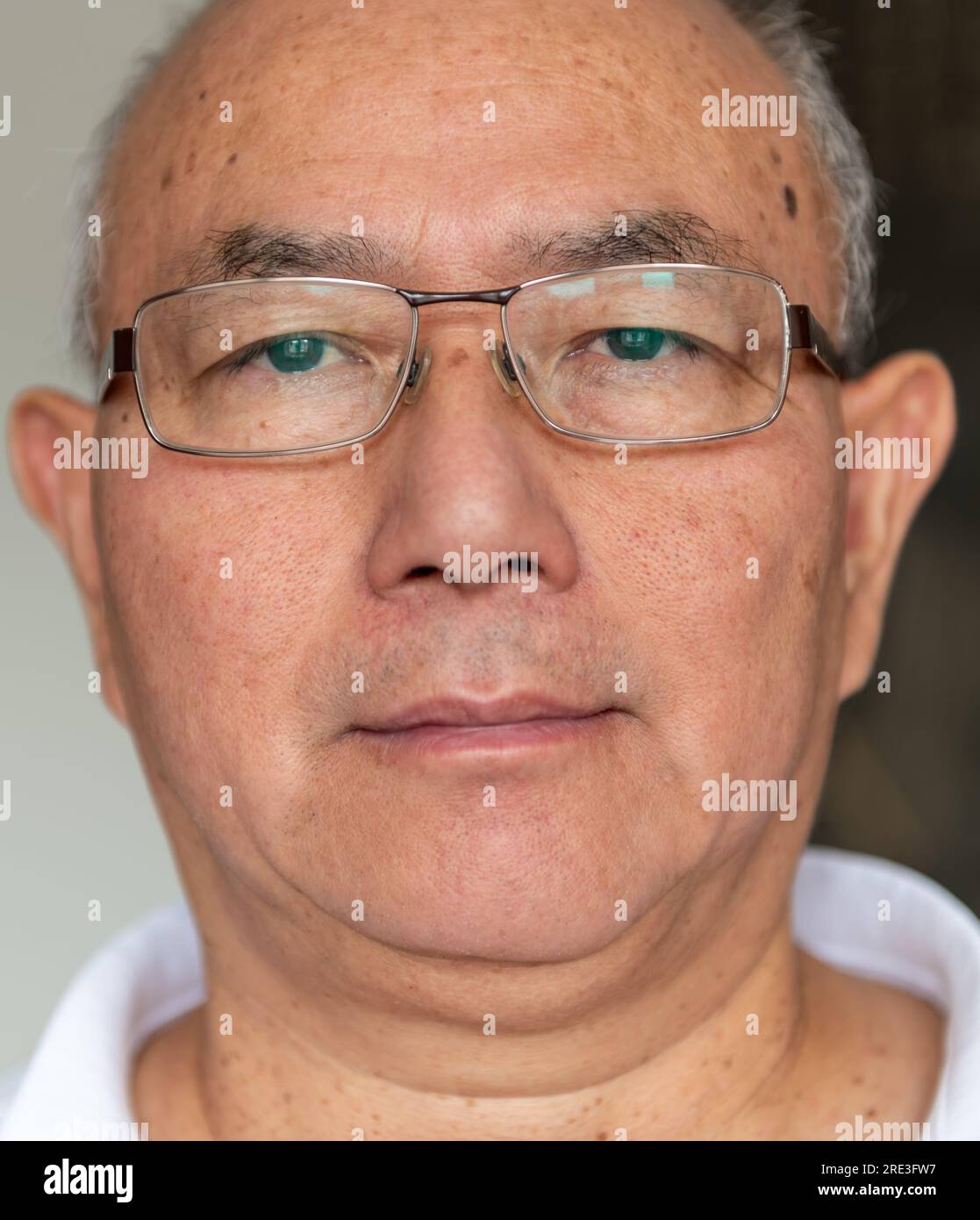 Un anciano que llevaba un par de gafas varifocales. Foto de stock