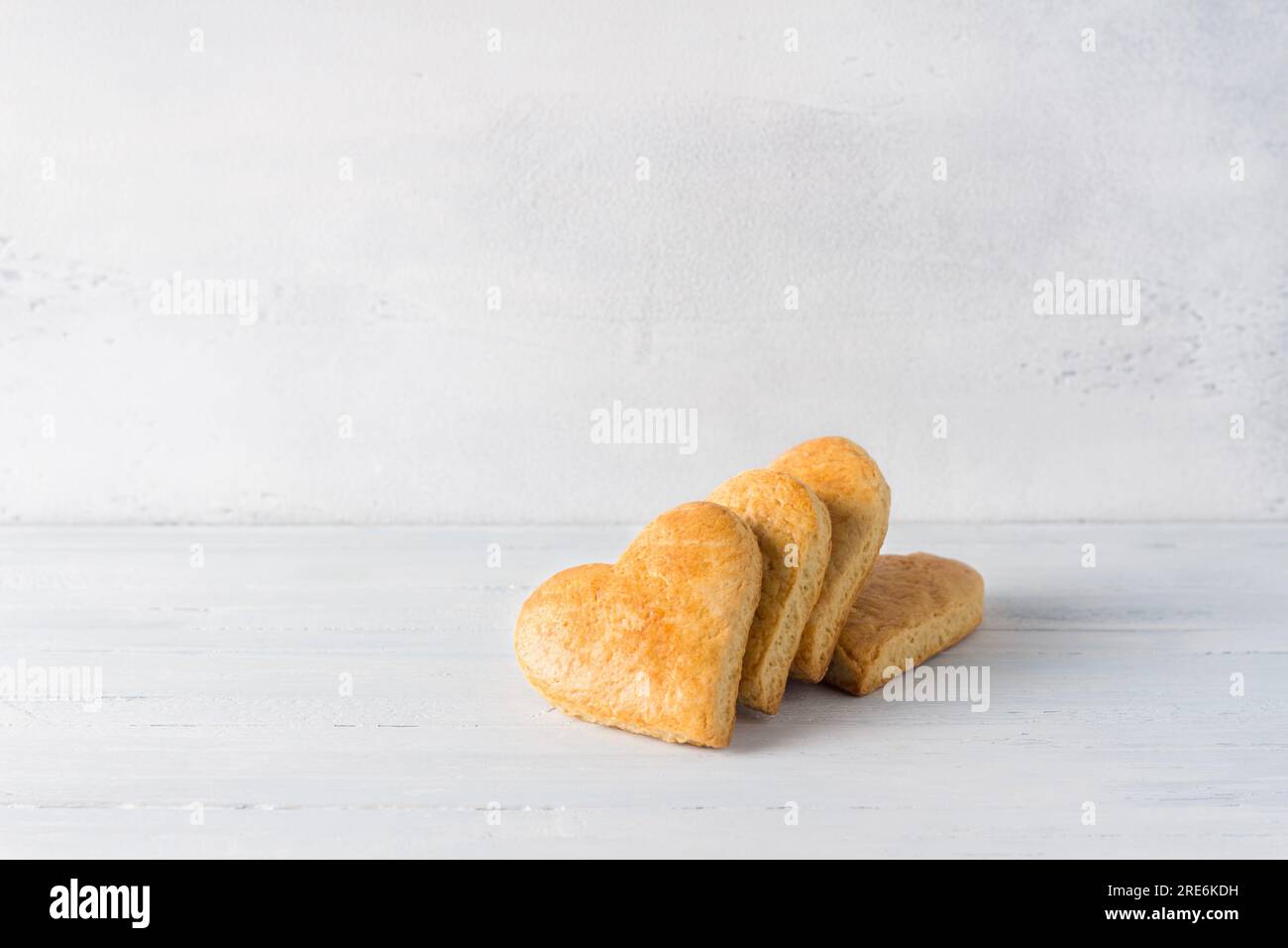 Galletas de pan corto en forma de corazón sobre un fondo azul claro. día de la cookie. Foto de stock