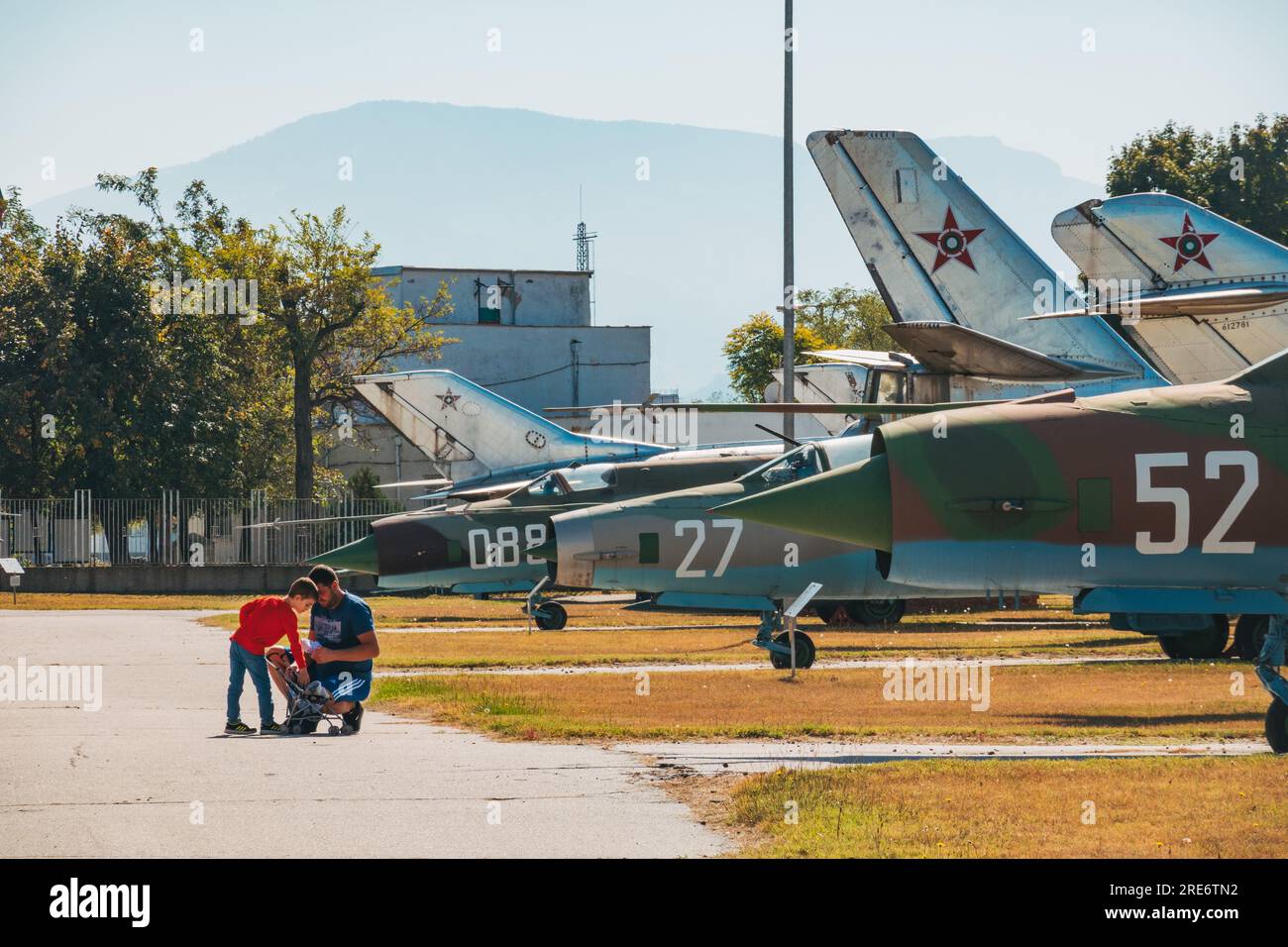 Un padre y un hijo hacen una pausa en un sendero en el Museo de Aviación en el aeropuerto de Plovdiv, Bulgaria Foto de stock