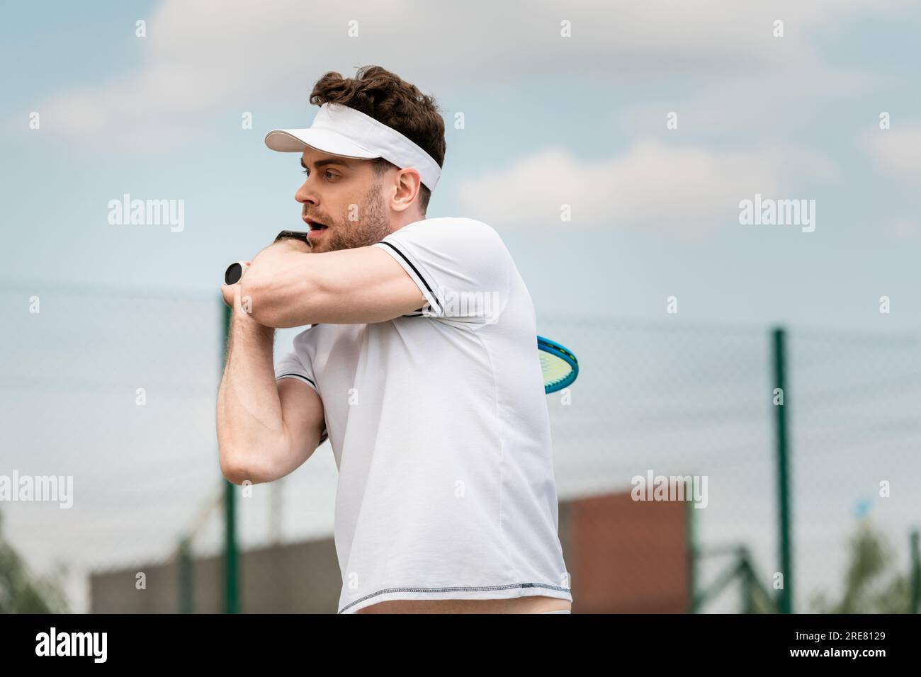 retrato de hombre guapo en gorra de visera jugando al tenis en la cancha,  revés, deporte y ocio, verano Fotografía de stock - Alamy
