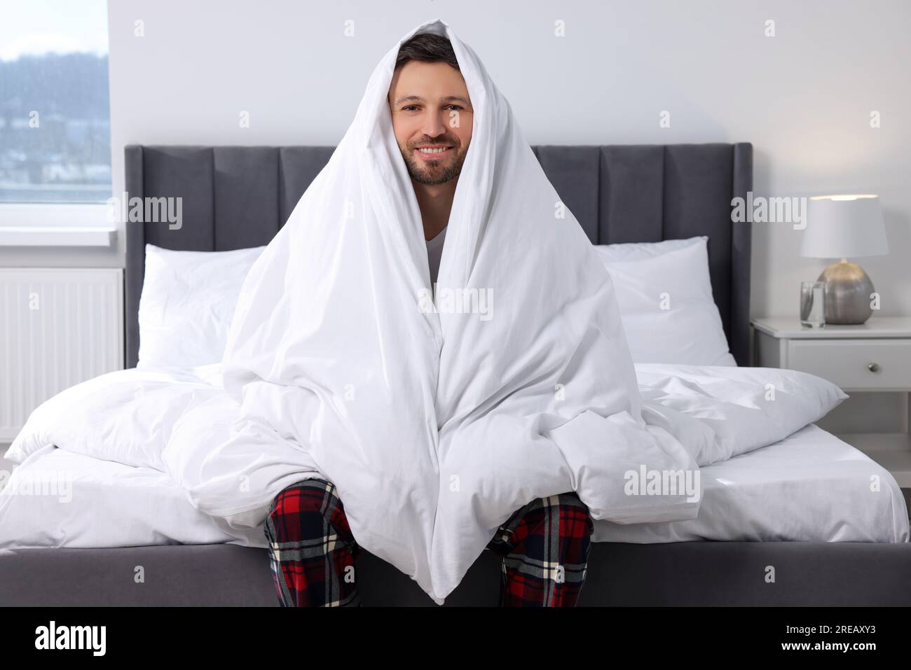 Hombre feliz envuelto en manta en cama suave en casa por la mañana  Fotografía de stock - Alamy