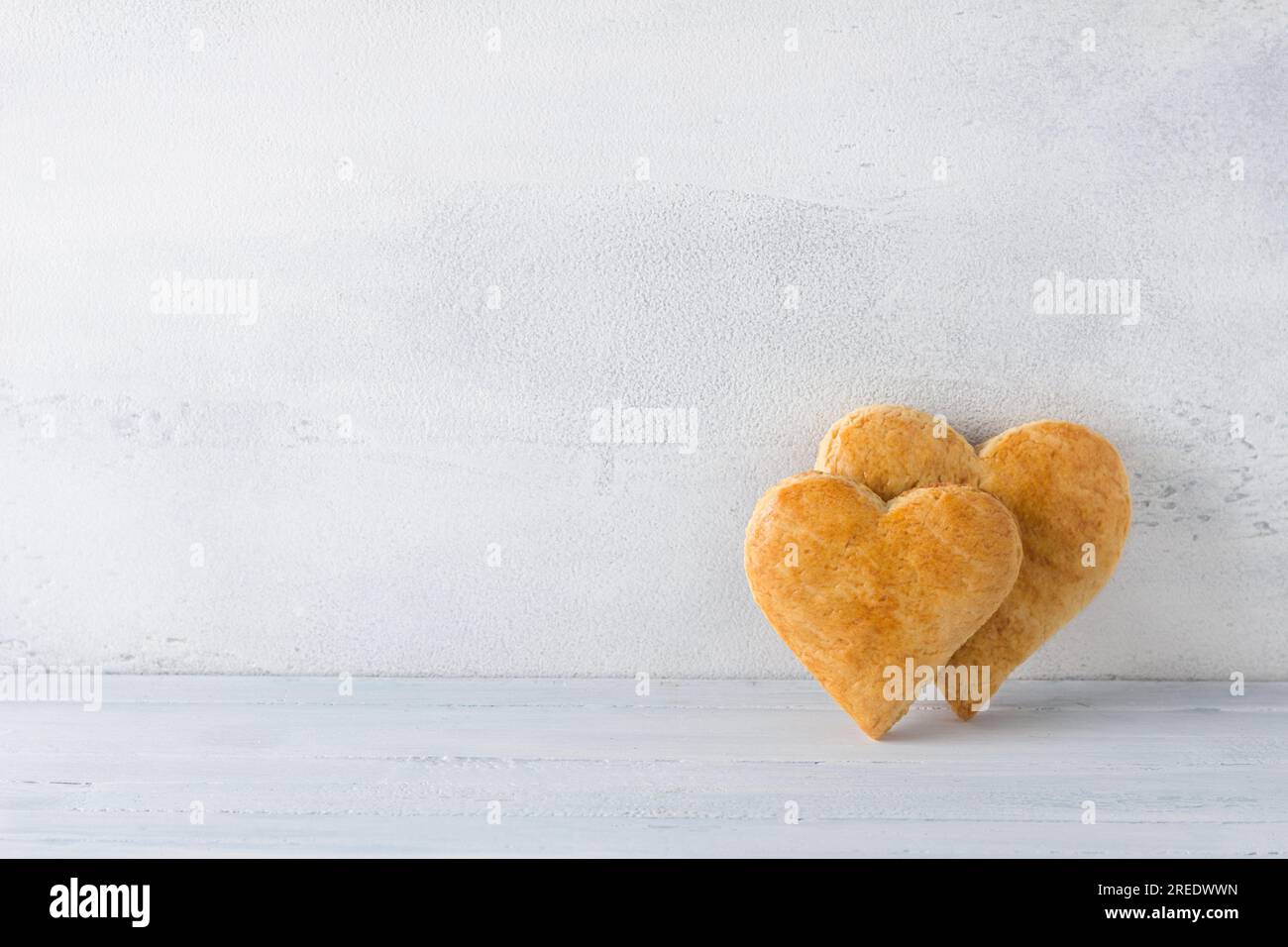 Galletas de pan corto en forma de corazón sobre un fondo azul claro. día de la cookie. Foto de stock