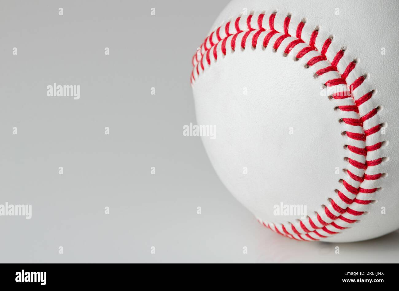 Primer plano de una pelota de béisbol blanca con puntos rojos sobre un fondo blanco Foto de stock
