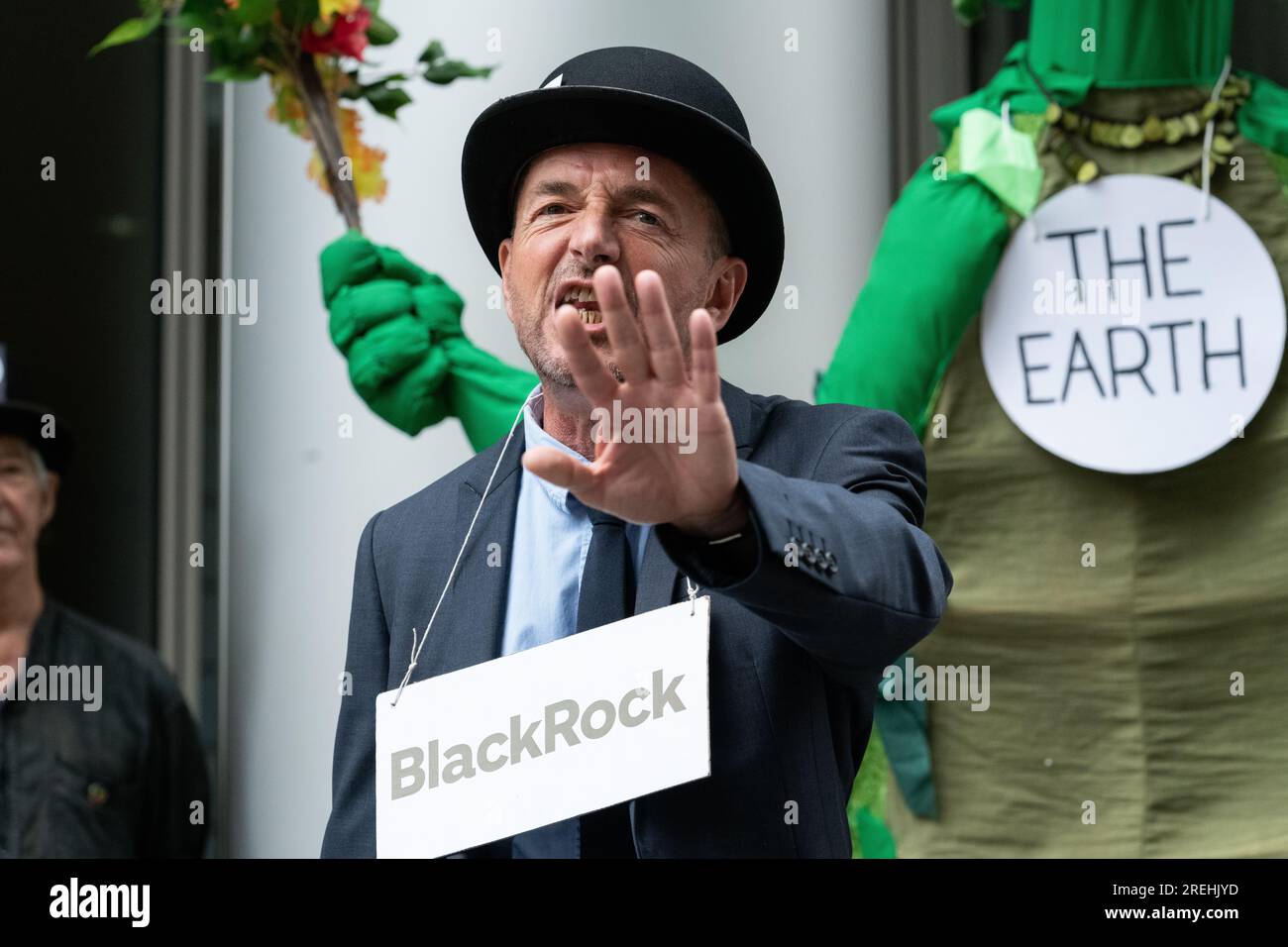 Londres, Reino Unido. 28 de julio de 2023. Un activista del clima vestido de empresario actúa durante una protesta teatral frente de la sede londinense de BlackRock, uno de los mayores gestores de fondos del mundo y que está fuertemente invertido en combustibles fósiles. La acción sigue a los comentarios del día anterior del secretario general de la ONU, António Guterres, de que 'el cambio climático está aquí. Es aterrador. Y es solo el principio'. Crédito: Ron Fassbender/Alamy Live News Foto de stock