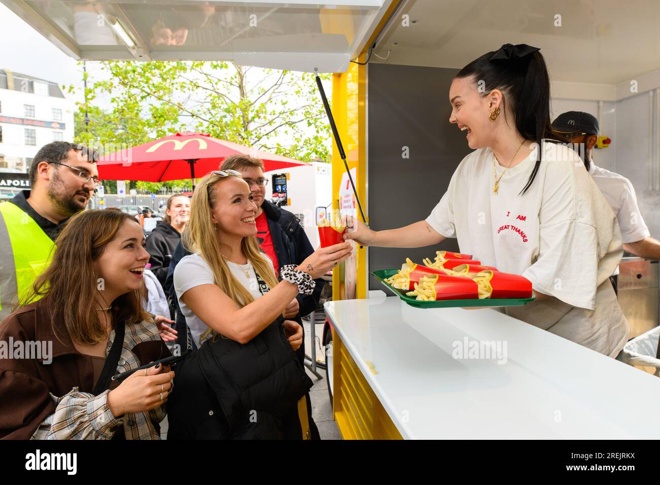 La cantante y compositora Anne-Marie (derecha) lanza su nuevo álbum sorprendiendo a los fans con una furgoneta personalizada de McDonald's Fries en las afueras de la estación de Kings Cross de Londres. Fecha de la fotografía: Viernes 28 de julio de 2023. Foto de stock