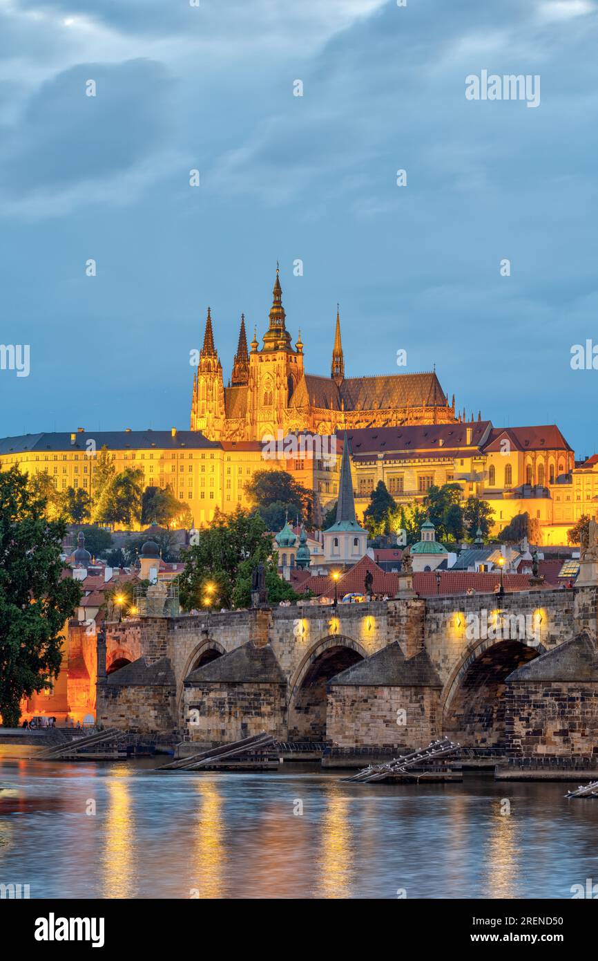 El St La catedral de Vitus con el castillo de Praga por la noche se eleva sobre el río Vltava con el famoso Puente de Carlos Foto de stock